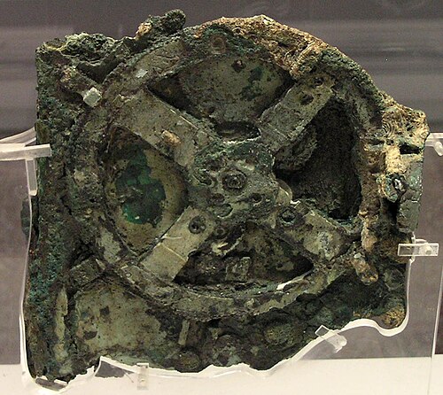 Fragment A of the Antikythera mechanism on display, showing corroded bronze gearwheels